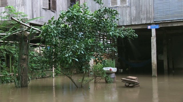 traditional wooden stilt-house with flood waters under the house