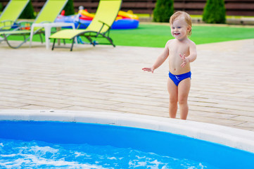 Naklejka premium Adorable toddler by the swimming pool
