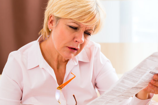 Seniorin liest mit Altersweitsichtigkeit Beipackzettel 