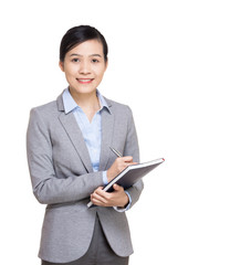 Asian business woman recording on notebook