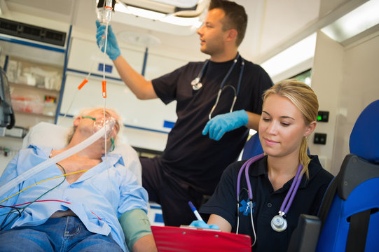 Paramedical Team Treating Man In Ambulance Car