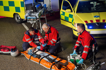 Paramedics helping motorbike driver on stretcher