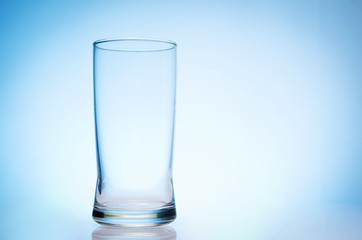 tall empty glass of water on bluebackground