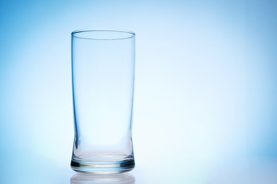 tall empty glass of water on bluebackground