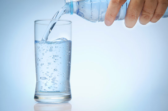 pure water is emptied into a glass of water from bottle