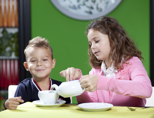 Happy children in cafe.The little boy and his elder sister