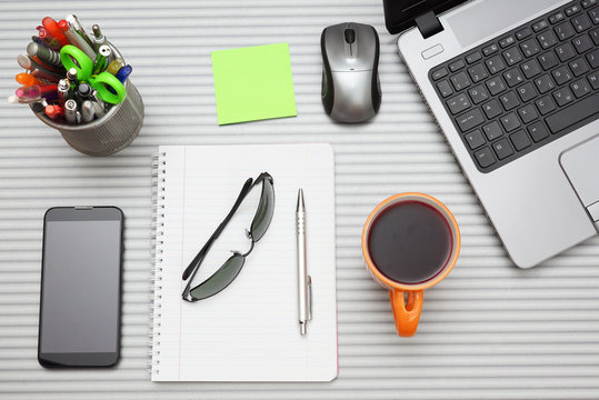 office desk with laptop with business accessories and cup of tea