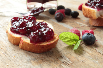 Crunchy bread with sweet jam on a wooden table