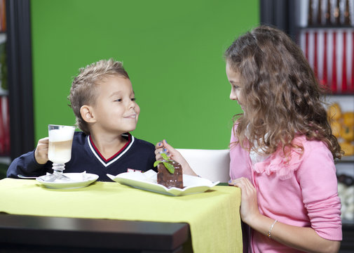 Sister and brother enjoying meal sitting at restaurant table