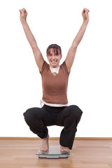 Woman standing on the scales and is happy about her weight