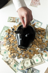 photo of woman inserting coin in piggy bank