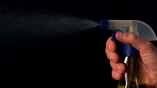 Woman spraying cleaner from a spray bottle