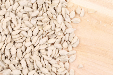 Close up of sunflower seeds on wooden board.