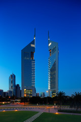 A profile of the iconic Emirates Towers in Dubai, UAE at dusk