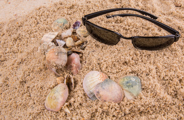Pair of sunglasses on beach sand