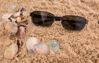 Fototapeta na wymiar Pair of sunglasses on beach sand