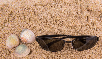 Fototapeta na wymiar Pair of sunglasses on beach sand