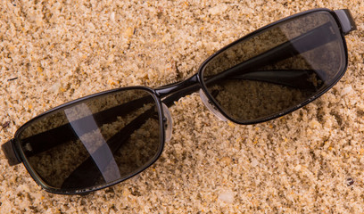 Pair of sunglasses on beach sand