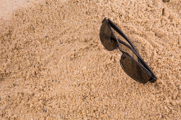 Pair of sunglasses on beach sand