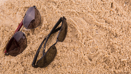 Pair of sunglasses on beach sand