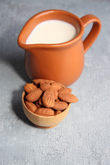 Almond milk in jug with almonds in bowl,