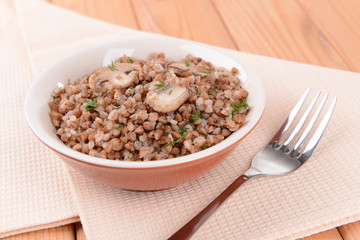 Boiled buckwheat in bowl on table close-up