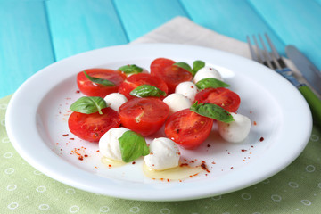 Caprese salad with mozarella cheese, tomatoes and basil