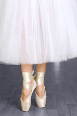 Ballerina legs in pointes in dancing hall © Africa Studio