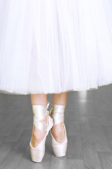 Ballerina legs in pointes in dancing hall © Africa Studio