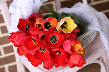 Bouquet of colorful tulips in wicker basket,