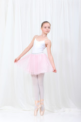 young beautiful dancer posing on a studio background