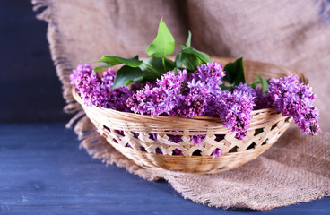 Obraz na płótnie Canvas Beautiful lilac flowers in wicker basket,
