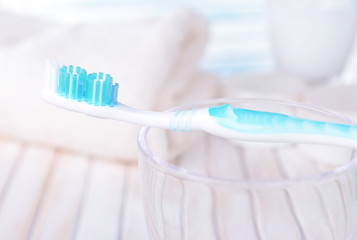 Toothbrush in glass on table on light background