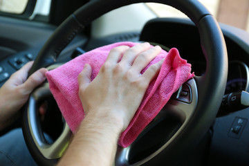 Hand with microfiber cloth polishing car