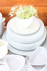 Different tableware on shelf, on wooden background