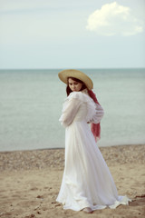 Fototapeta na wymiar woman at the beach wearing vintage dress