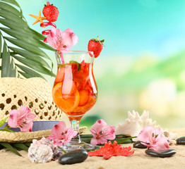 Refreshing strawberry cocktail on sand beach