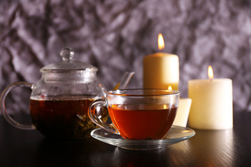 Composition with tea in glass teapot and candles