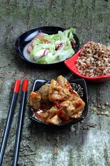 stew and salad on a background of cherry bark