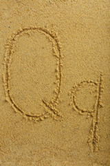 Alphabet letter written on wet beach sand