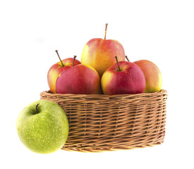 Red and green apples in a wicker baskets.