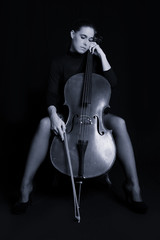Beautiful brunette holding cello with selective light in red dre © Alta Oosthuizen