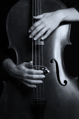 Beautiful woman holding a cello with selective light and black d