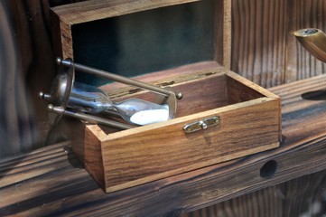 Hourglass on old brown vintage wooden box