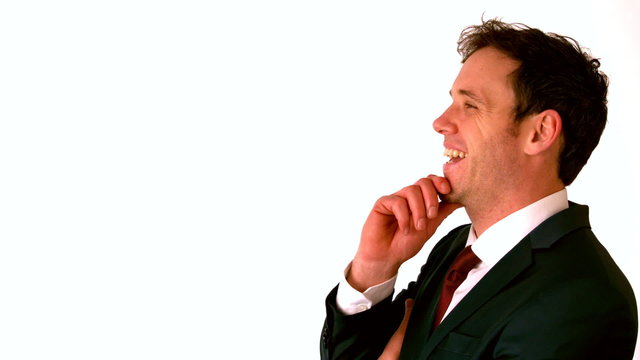 Happy businessman laughing with hand on chin