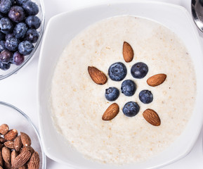 Bowl of oatmeal porridge with walnuts  and blueberry