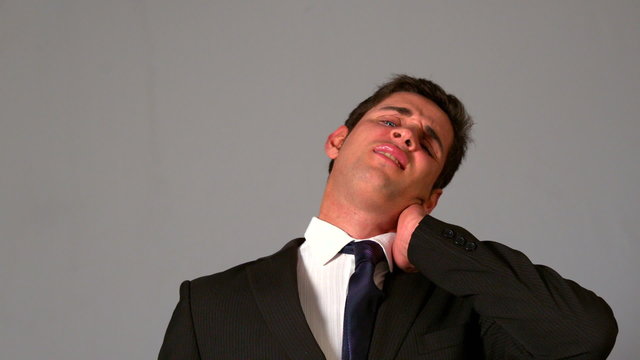Businessman rubbing his sore neck