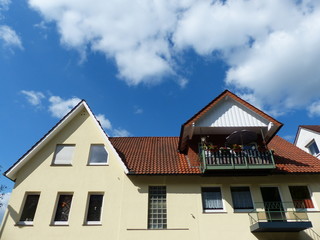 Wohnhaus mit spitzem Giebel, Dachgaube und Balkons im Sommer bei Sonnenschein in Oerlinghausen bei...