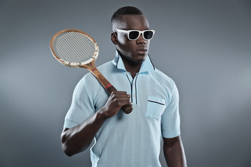 Retro black african tennis player wearing blue shirt and white s