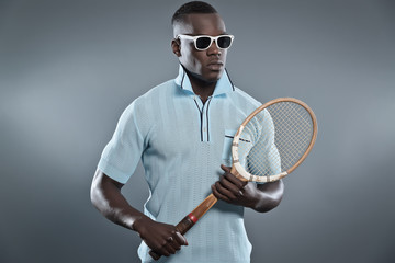 Retro black african tennis player wearing blue shirt and white s